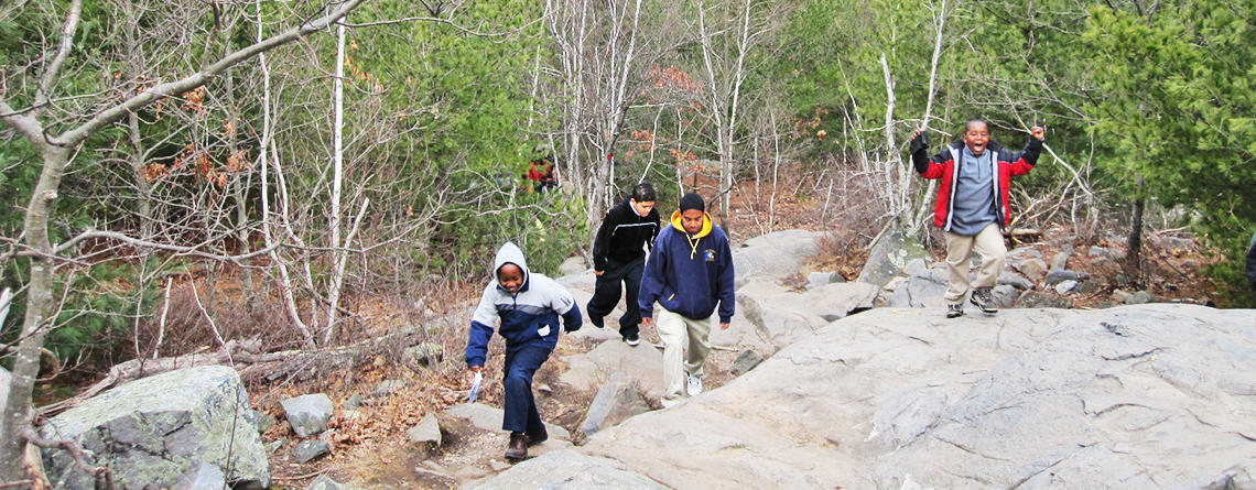 Boys hiking up boulder trail at Blue Hills Trailside Museum