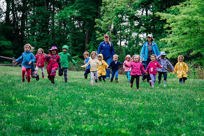 Drumlin preschoolers running outdoors in rain jackets © Emily Haranas