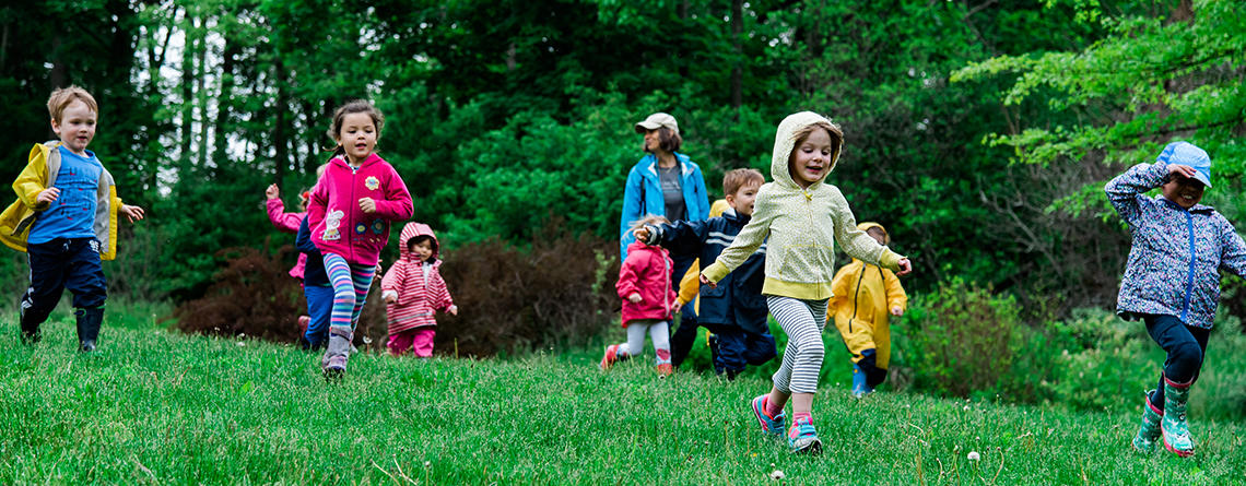 Preschoolers running down a hill at Drumlin Farm Wildlife Sanctuary