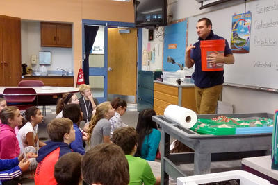 Mass Audubon South East educator Chris Hitchener leads a school program about the water cycle