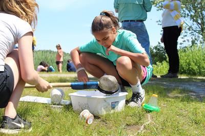 Teen examining organisms in a pond water sample
