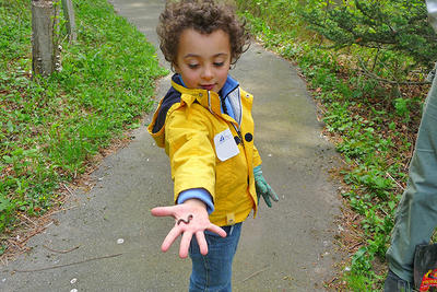A young boy showing off the worm he found in spring at Blue Hills Trailside Museum