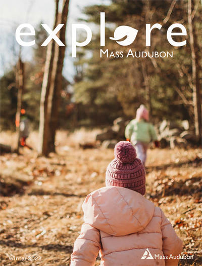 Cover of "Explore" Winter 2022 - Young children in winter clothes running up a hill