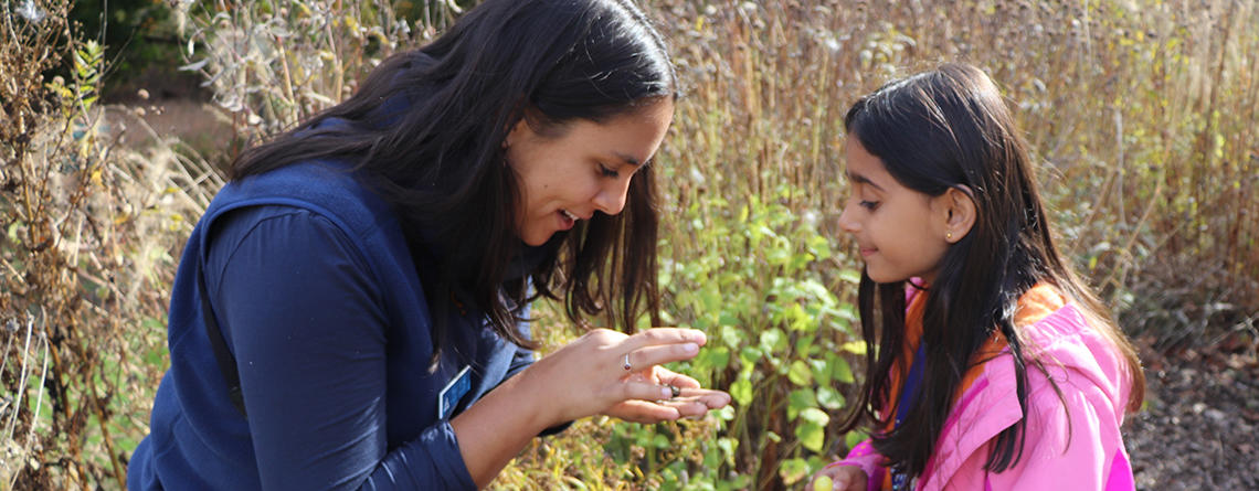 Teacher Naturalist showing a seed to a child