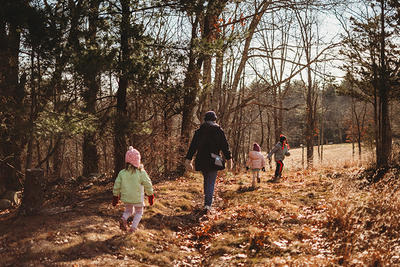 Parent with children of different ages walking on a trail in late fall