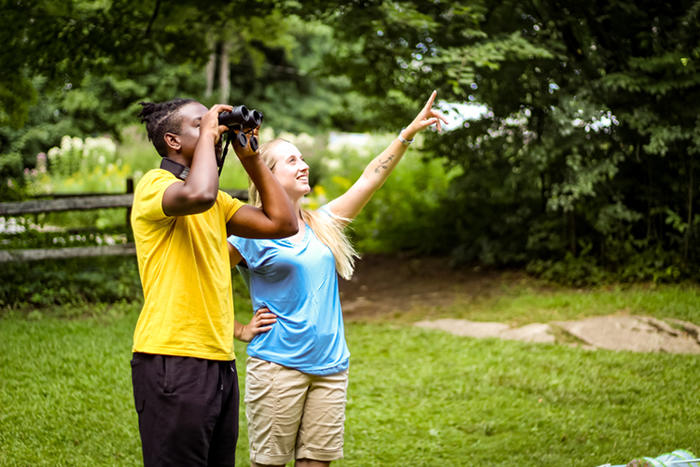 Young woman & man birding together at Drumlin Farm Wildlife Sanctuary in the summer