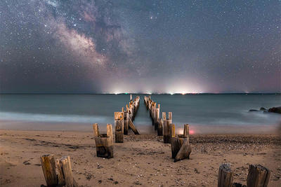 Starry sky and city lights on a beach in Falmouth © Evan Guarino