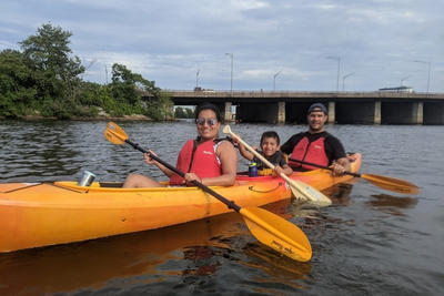A family of three kayaking on the Charles River