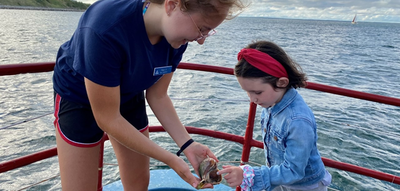 And educator showing a child a sea snail