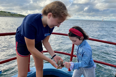 Showing off a shell on the bow of a boat