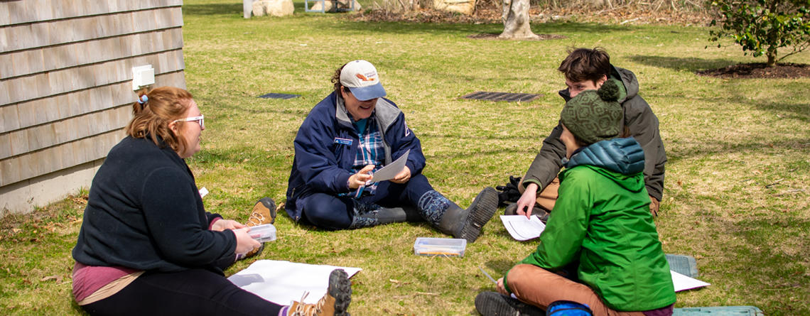 Teens sitting in a group on the grass