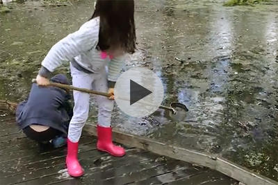 Video still of a child by a pond