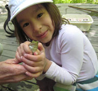 Girl with a frog in her hands