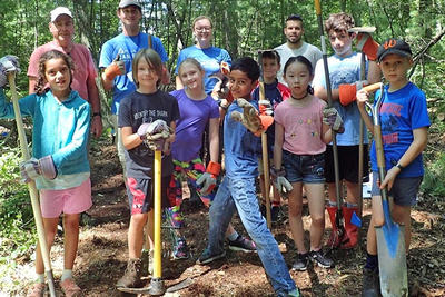Young campers helping build a trail at Broadmoor Wildlife Sanctuary