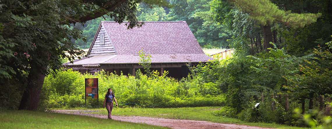 Person walking the farmyard loop trail at Drumlin Farm Wildlife Sanctuary © Gretchen Ertl