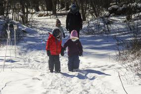 Habitat preschoolers walking hand-in-hand along a snowy path