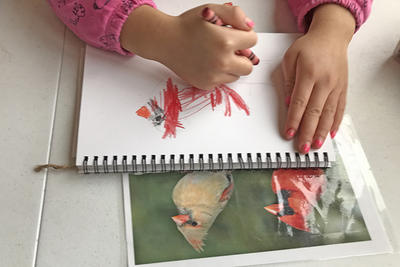 Long Pasture Nature Preschool Explorer drawing a bird with crayons