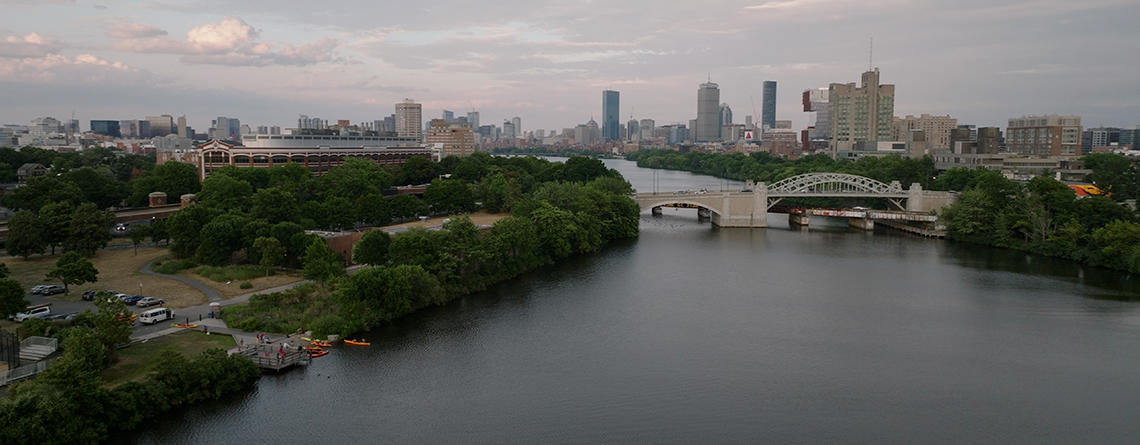 overview of kayaks along Charles River with city in background