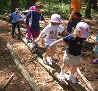 Children playing on logs at Moose Hill Wildlife Sanctuary