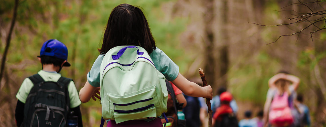Group of kids walking in the woods during April Vacation 2021 program at Moose Hill Wildlife Sanctuary