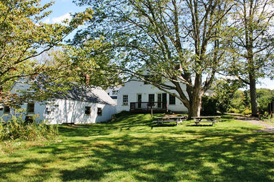The Nature Center's main building & barn in summer at Oak Knoll Wildlife Sanctuary
