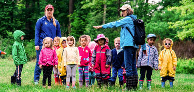 A group of campers and two counselors in a field