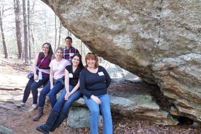 Group of teachers under a glacial boulder