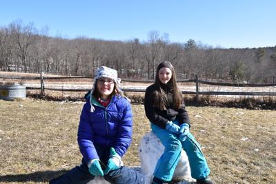 Kids sitting on melting snowmen during school vacation week at Wachusett Meadow Wildlife Sanctuary