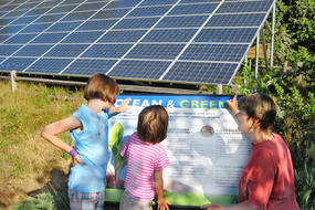 Woman with children at solar energy sign