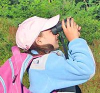 Girl looking through binoculars at Monadnock Conservation Center