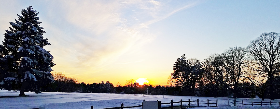 Sunset over a snowy field at Drumlin Farm Wildlife Sanctuary © Elizabeth Ninemire
