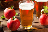 Glass of hard cider with apples