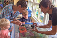 A Joppa Flats education volunteer showing a horseshoe crab to a family