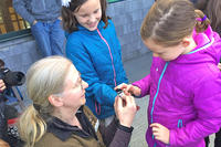 Deb La Roy helping kids release a banded chickadee