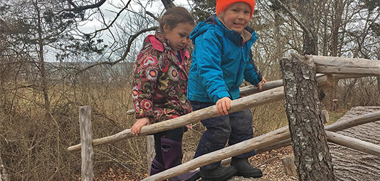 Preschoolers playing in Long Pasture's Nature Play Area