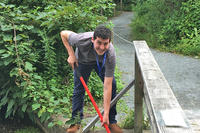 Volunteer Erich Wilmot works to clear blockage on the first spillway