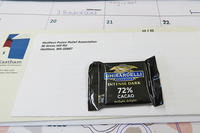 A small square of chocolate on top of letters received in the mail