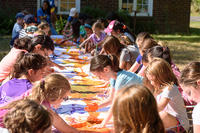MABA campers painting a long mural on paper