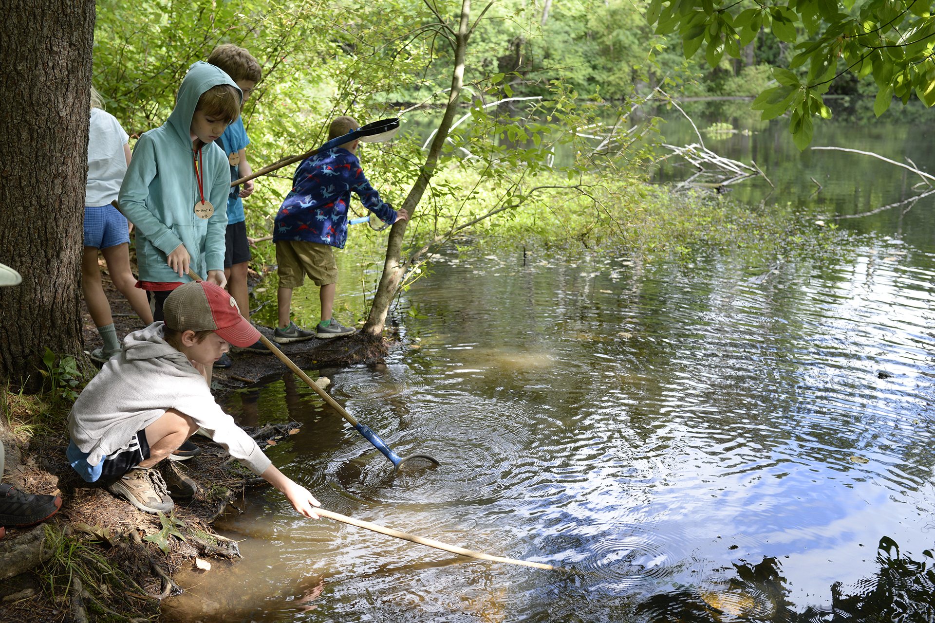 Campers inspecting the shallow end of a pond