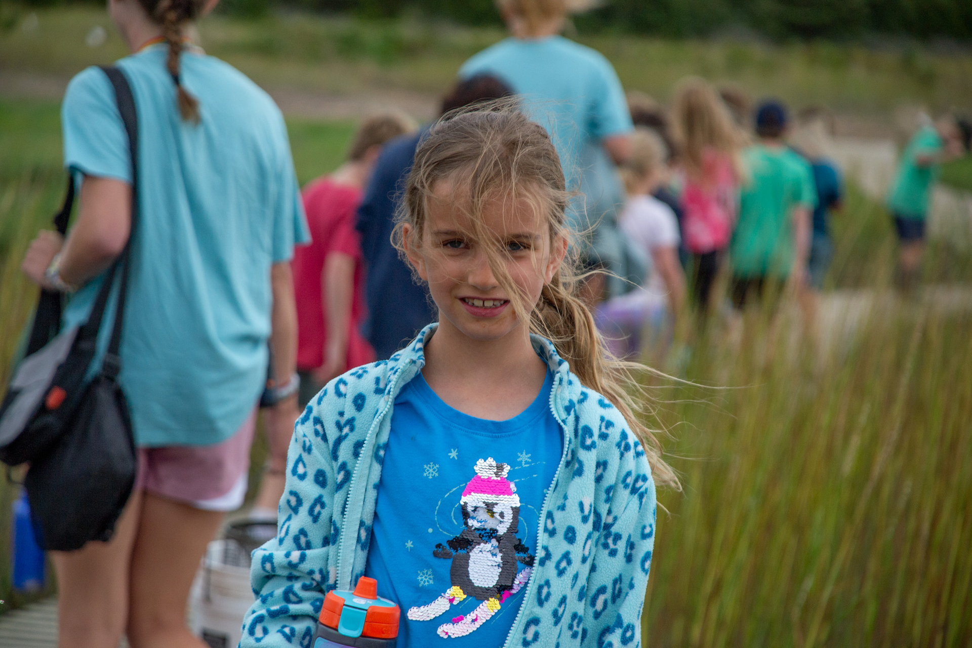 camper smiles at camper while a group walks behind her.