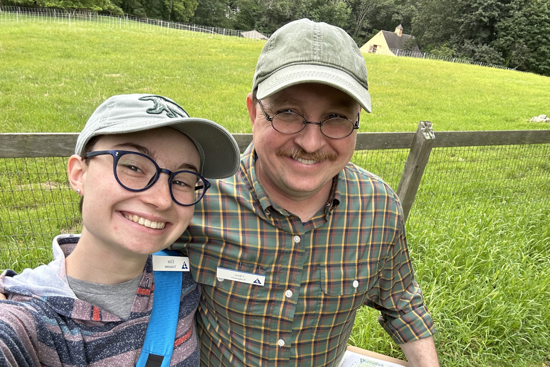 Father and daughter smiling together in front of fence