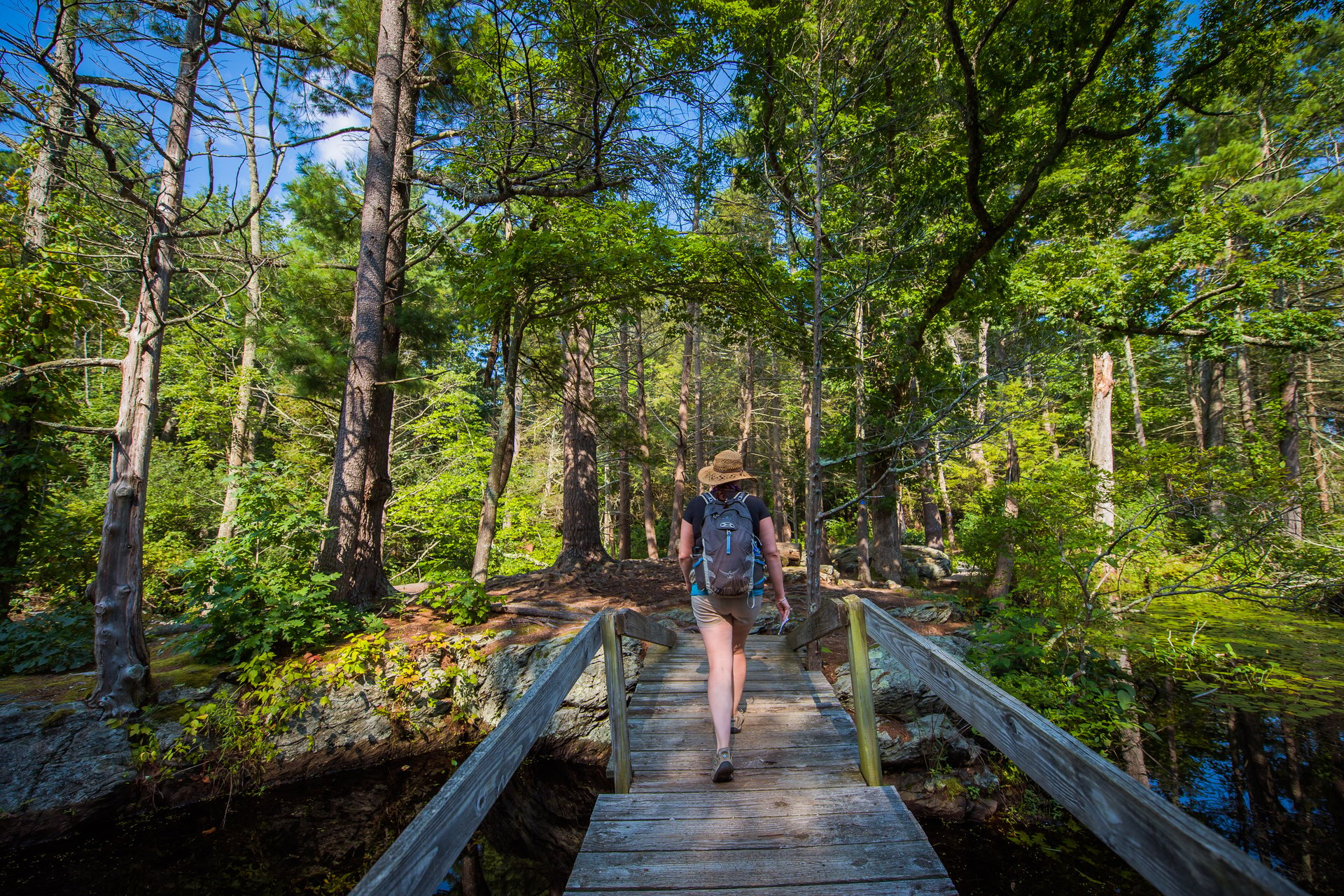 Woman with backpack walking on a boardwalk