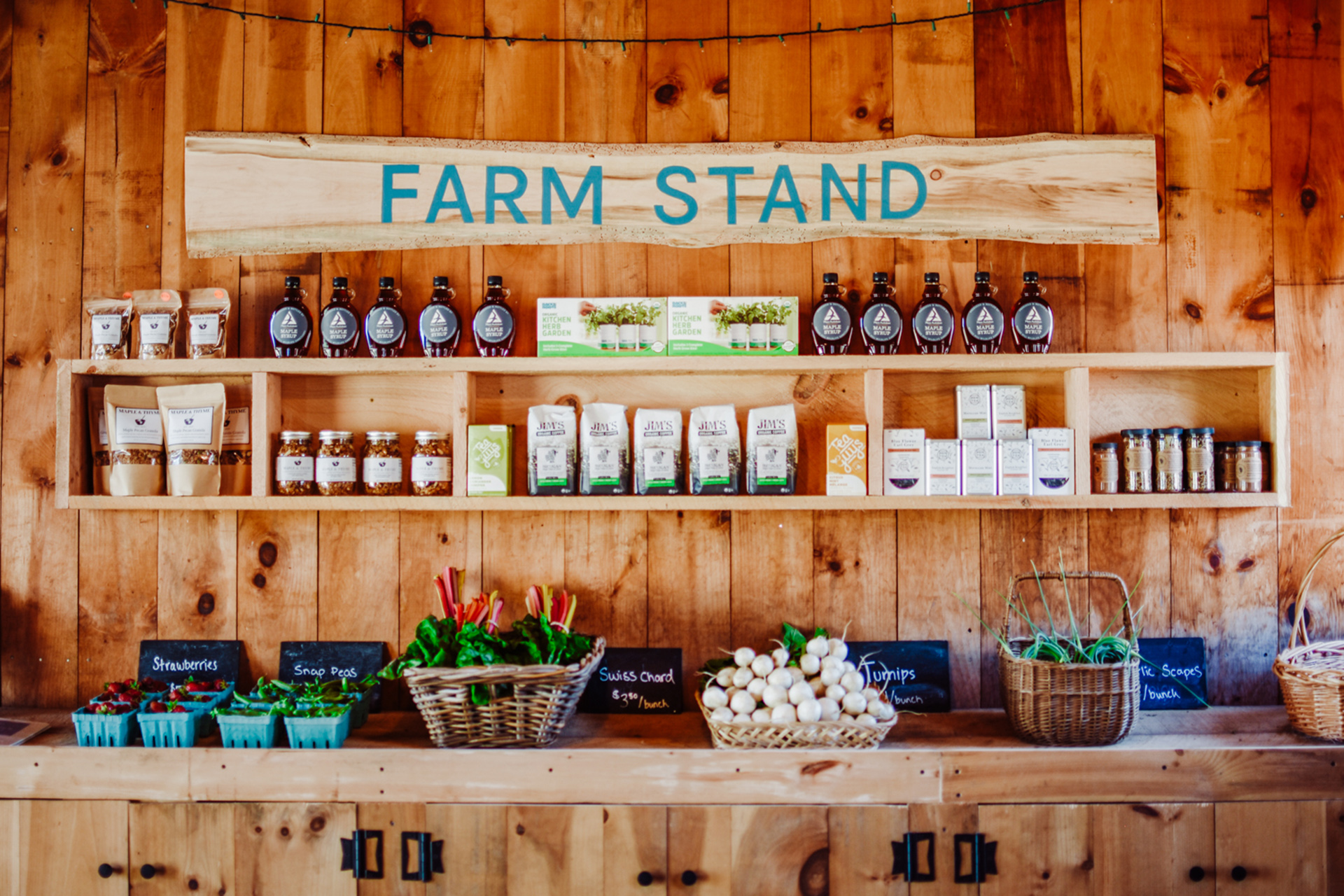 Bottles of maple syrup, honey, and assorted other sundries on shelves at the Moose Hill farm stand