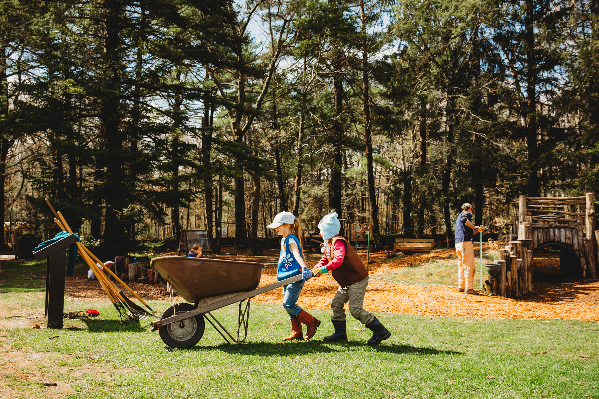 Two children pushing a wheelbarrow