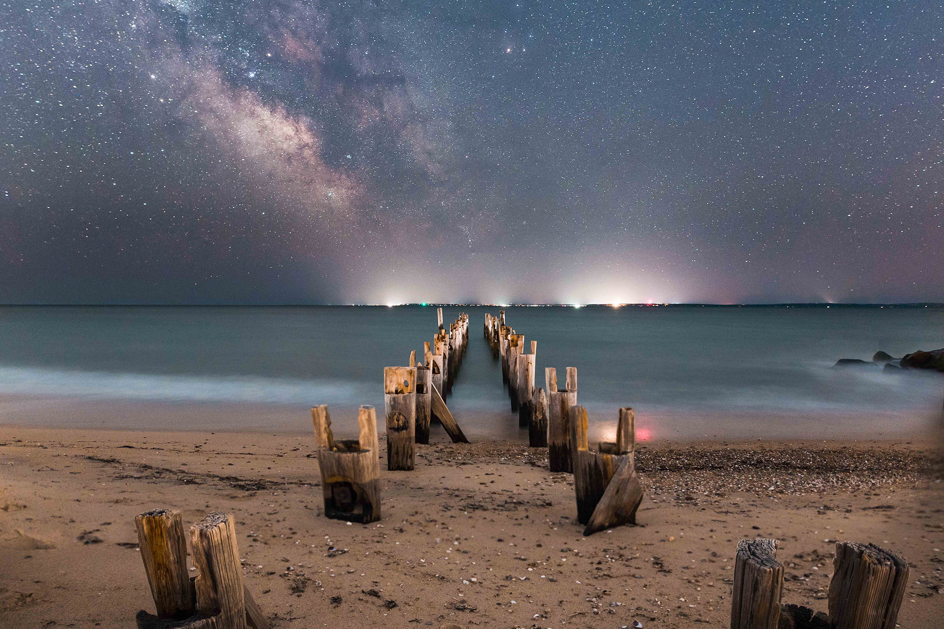 Starry sky and city lights on a beach in Falmouth © Evan Guarino