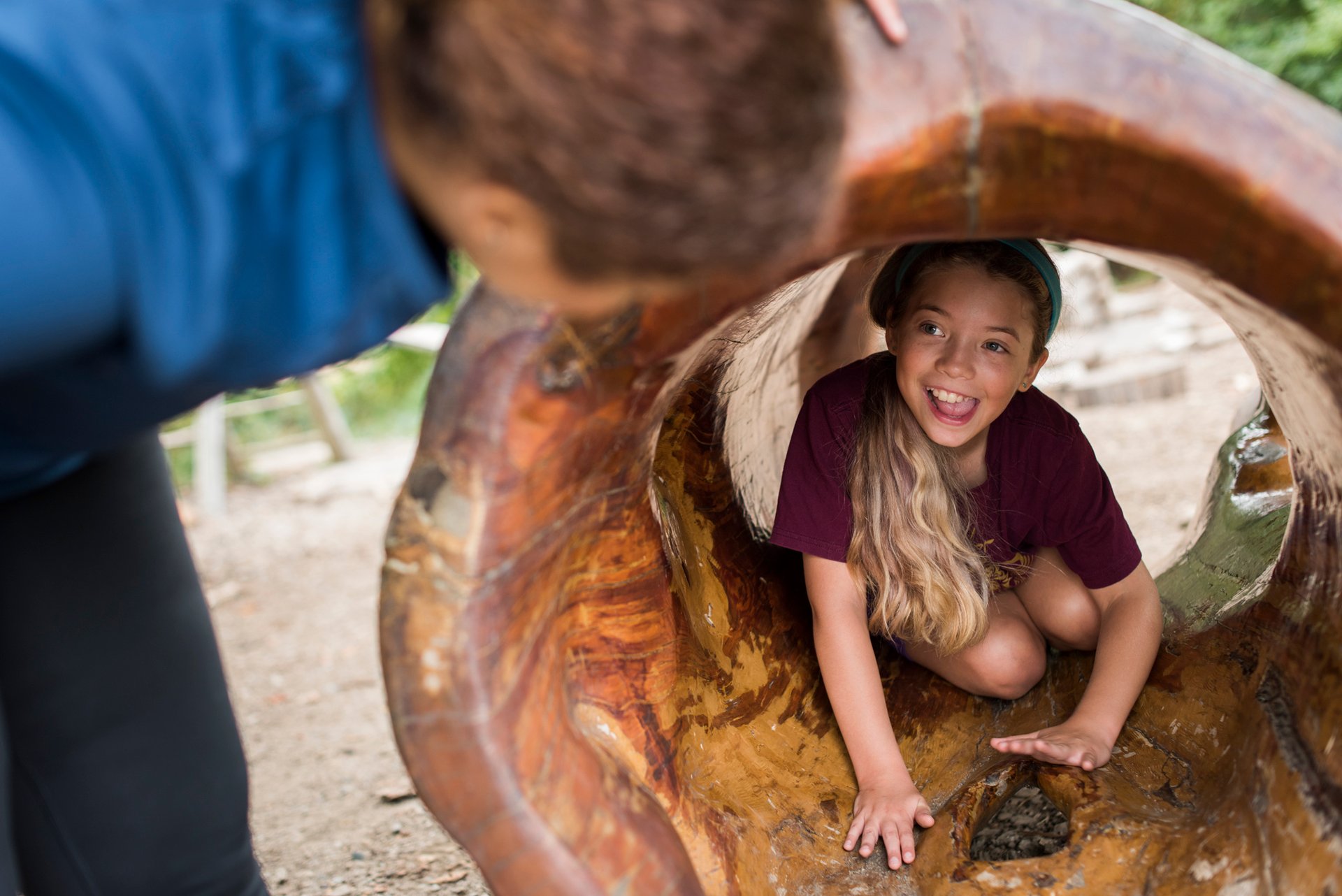 Child in nature play area log