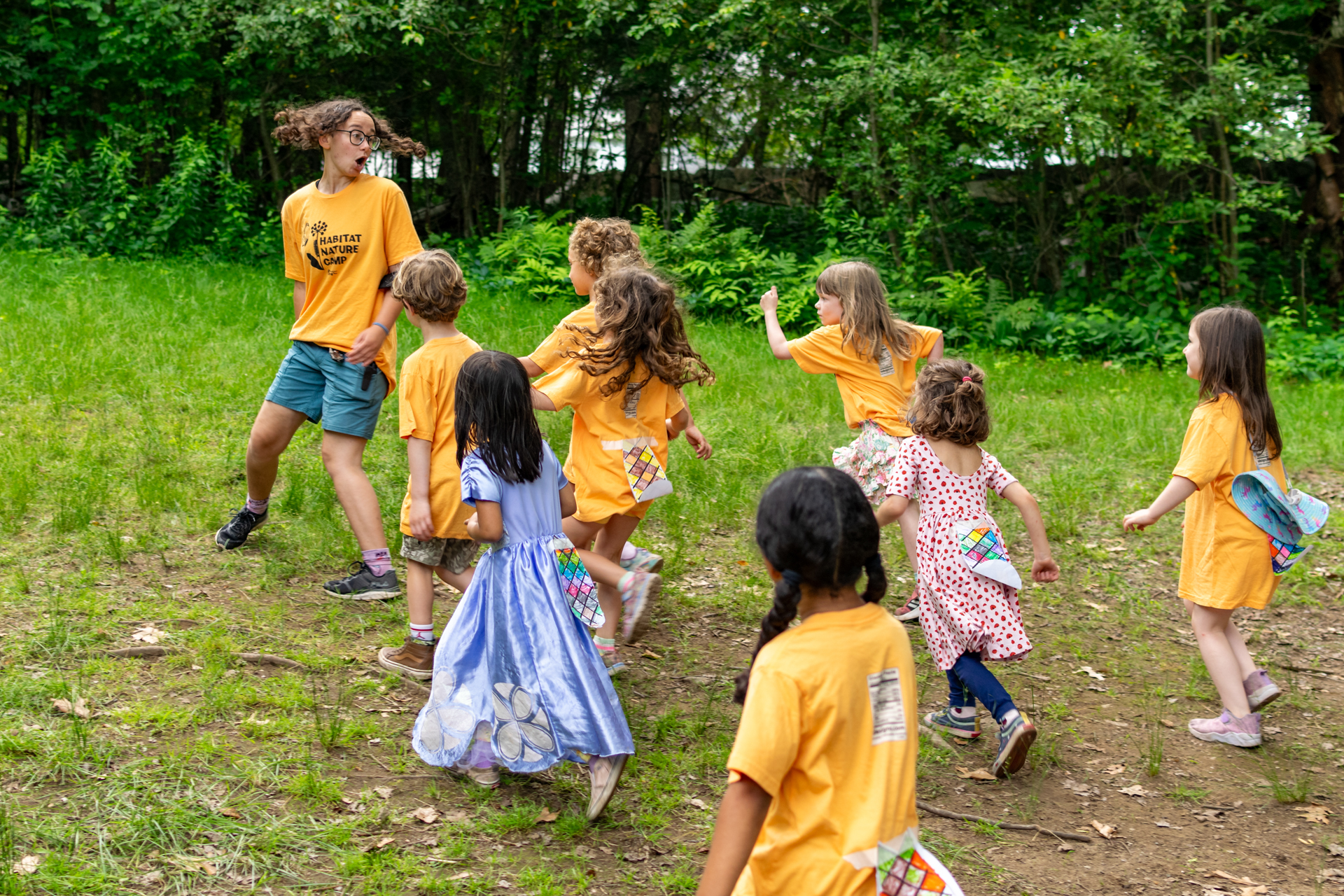 A Habitat camp counselor spins around to look at campers running up from behind who must freeze in place or lose the game