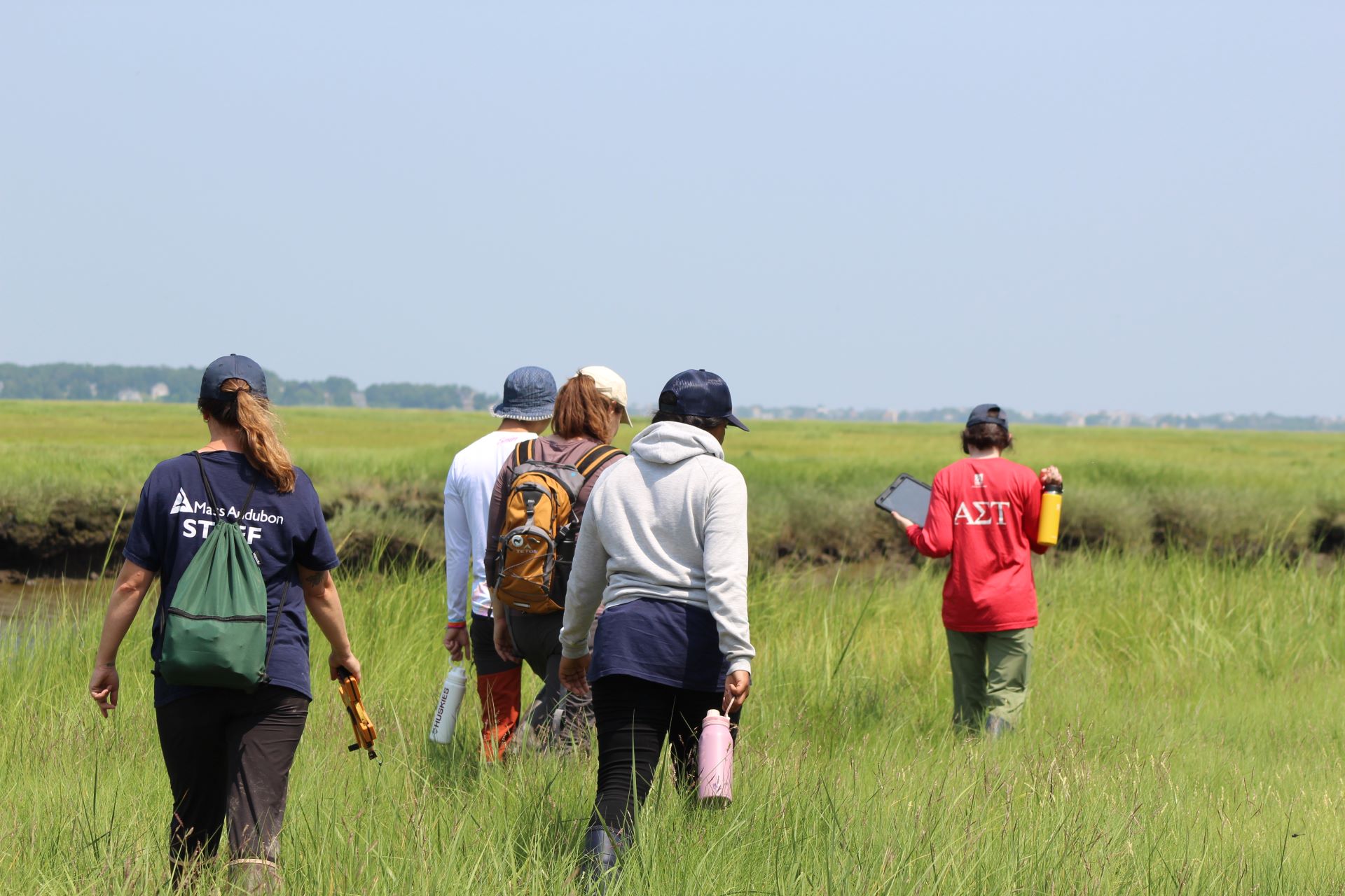 Environmental Fellowship Program participants walk in grassy land.