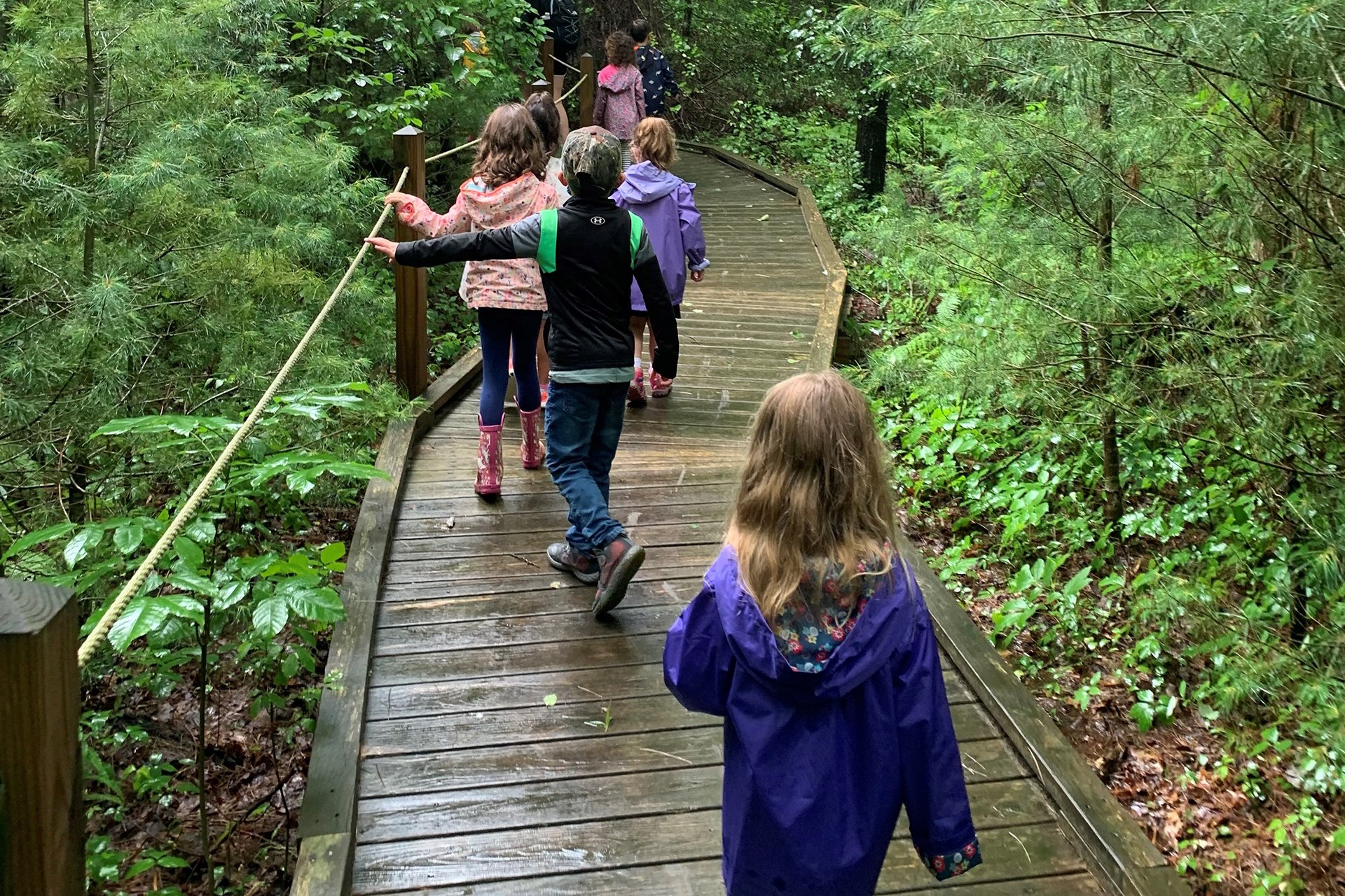 Campers walking on a boardwalk in the rain