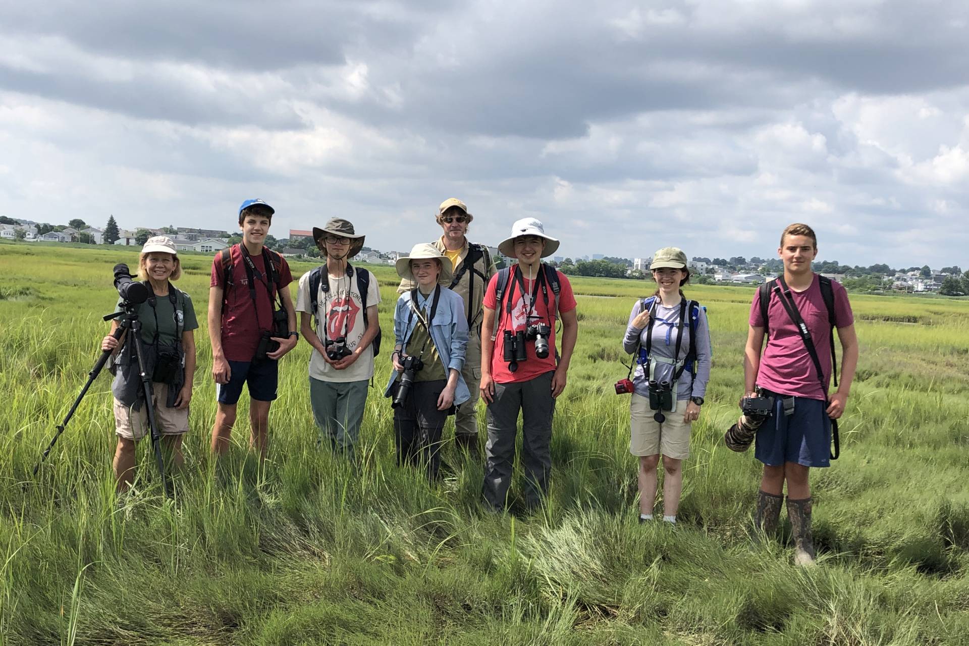 A group of teen birders pose with cameras amid Rumney Marsh.